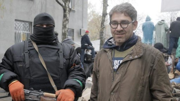 Captive ... US reporter Simon Ostrovsky, right, stands with a Pro-Russian gunman at seized police station in the eastern Ukraine town of Slovyansk. Pro-Russian gunman now claim to be holding the Vice News journalist.