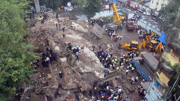 Firefighters and rescue workers are seen working at the site of the building collapse in Mumbai.