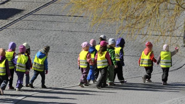 A group of nursery school children in yellow vests out for a walk in Stockholm.