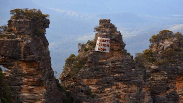 Human intervention: a banner hangs off the Three Sisters on Sunday.