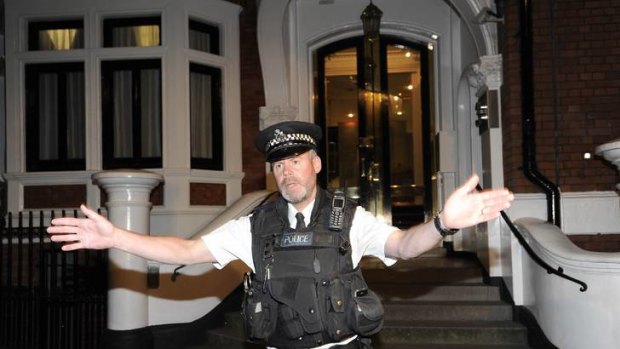 A police officer gestures outside Ecuador's embassy housing Julian Assange.