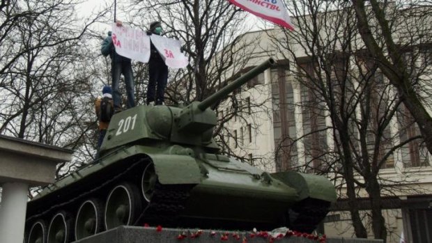 Pro-Russian demonstrators stand on a T-34 Soviet tank, set as a WWII monument in the Crimean parliament in Simferopol. 