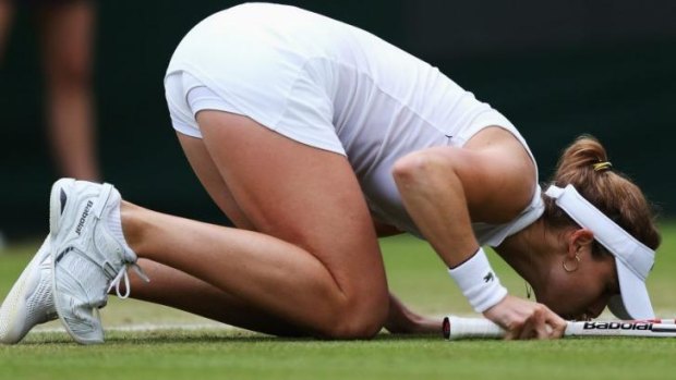 Alize Cornet kisses the grass to celebrate her first victory over a top-20 player at a Grand Slam event.