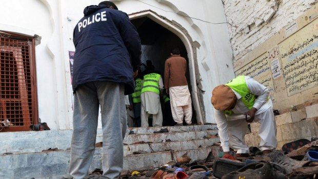 Pakistani police gather evidence following the bomb attack on a Shiite mosque.
