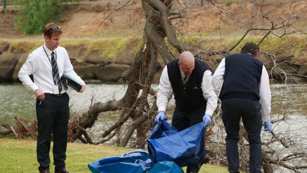 Police investigating the death of Brendan Bernard take away evidence from the banks of the Maribyrnong River. 