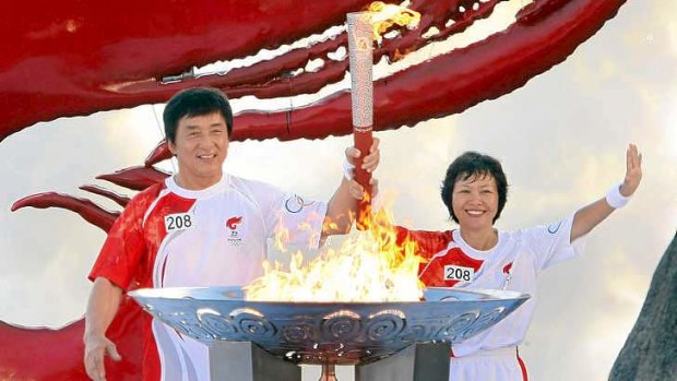 Jackie Chan carries the Olympic torch during the lead-up to the Beijing games in 2008.