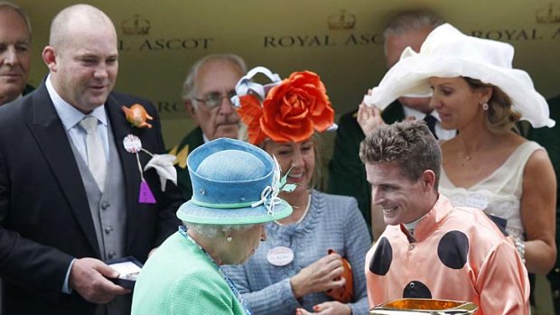 Jockey Luke Nolen receives his winner's memento from Queen Elizabeth.
