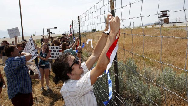 Protesters tie red, white and blue ribbons to the fence of a National Security Agency facility being built in Utah.