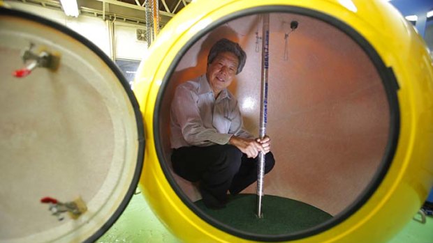 Cosmo Power Co. President Shoji Tanaka inside the spherical earthquake and tsunami shelter "Noah" made of fibre enforced plastic.