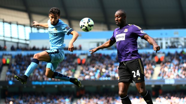 Jesus Navas of Manchester City, left, heads the ball under pressure from Carlton Cole.