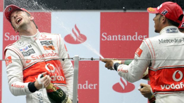 Second-placed Lewis Hamilton sprays champagne at teammate and compatriot Jenson Button on the podium in Shanghai.