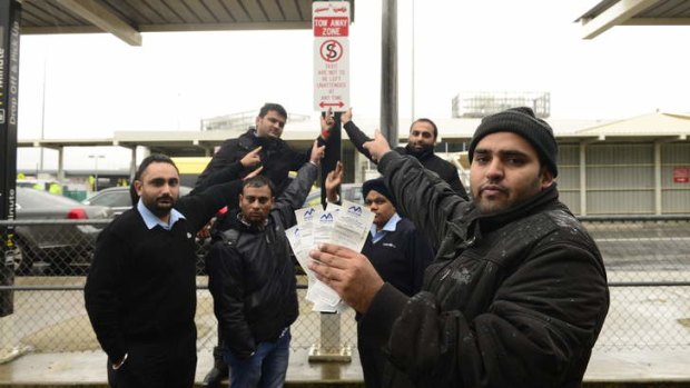 Taxi driver Harkaran Singh holding some of the parking tickets he and his colleagues have received since Melbourne Airport changed the signage to a no standing zone.