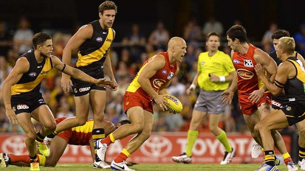Surrounded by Tigers, Gary Ablett of the Suns mulls his next move.