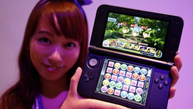 A booth girl holds a Nintendo 3DS displaying GungHo Online Entertainment Inc's new game "Puzzle & Dragons Z" at the Tokyo Game Show on Thursday.
