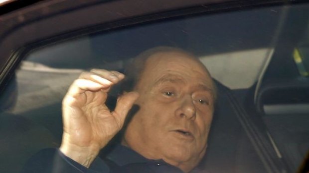 Silvio Berlusconi waves from his car as he leaves the Sacra Famiglia  community in Cesano Boscone, near Milan.