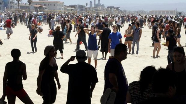 Treasure hunt: people scour the sand at Hermosa Beach in California for the cash.