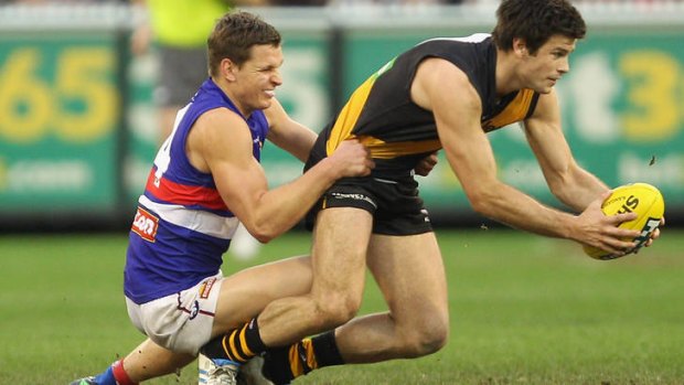 ROUND 20: Clay Smith tackles Trent Cotchin during round 20.