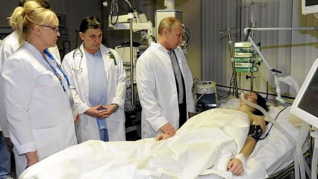 Russia's President Vladimir Putin visits Russian Olympic skicross racer Maria Komissarova at a hospital in Sochi.
