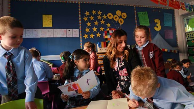 Practical placement: Emma Semrani with kindergarten children (left to right) Riley, 5; Sienna, 5 (pigtails); Emma, 5; and Matthew, 6, at Holy Family Primary School, Menai, on Tuesday.