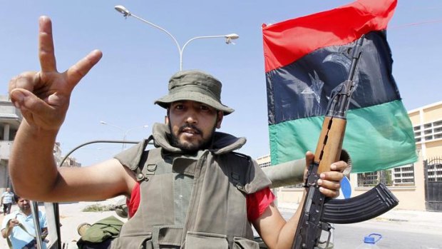 A rebel makes the victory sign near Bab Al-Aziziya in Tripoli.