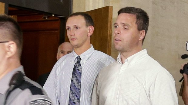 Former Milwaukee police officers Graham Kunisch right, and Bryan Norberg left, who were shot and seriously wounded by a gun purchased at a Wisconsin gun store, leave court.