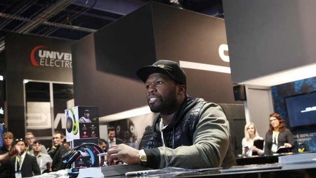 50 Cent signs autographs at a booth promoting SMS Audio.