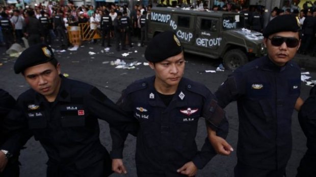 Policemen link arms near a military vehicle vandalised by protesters at Bangkok's Victory Monument on Wednesday.