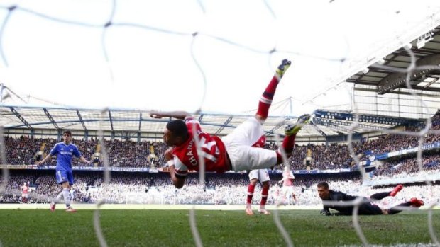 What was he thinking: Arsenal outfielder Alex Oxlade-Chamberlain dives to save a shot on goal by Chelsea with his hand.