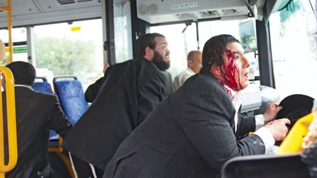 Blood on the streets ...  Orthodox Jews take cover as their bus comes under attack during the funeral of Samer Sirhan in Jerusalem's Old City.