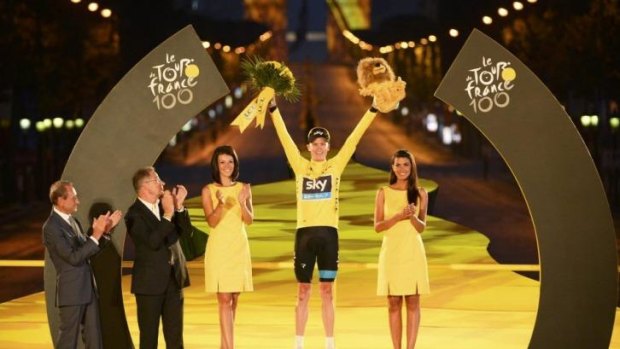 The 2013 Tour de France winner Chris Froome on the podium, flanked by the usual podium girls.