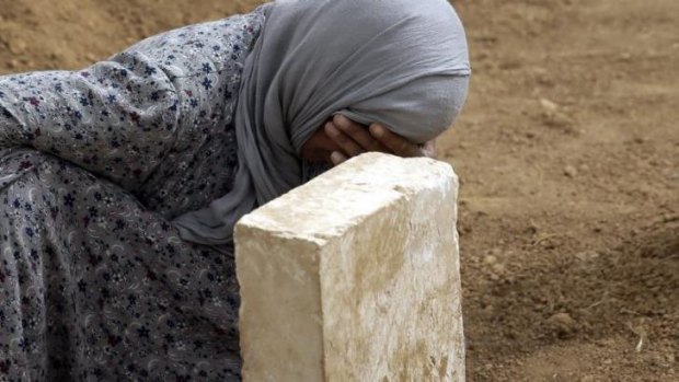 Rabia Ali mourns at the grave of her son, a Kurdish fighter killed in fighting with Islamic State militants.