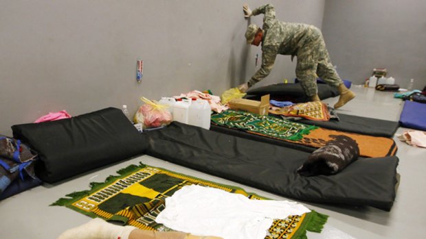 Tarnished reputations: A US military policeman searches a detainee's belongings at the Camp Cropper detention centre in western Baghdad.