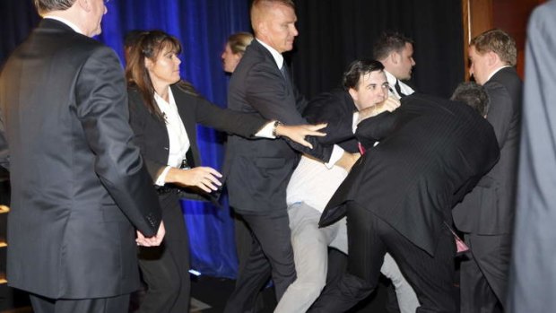 Security throw out a man who hopped on stage during Tony Abbott's victory speech.