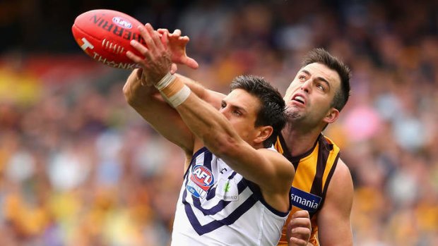 Brian Lake of the Hawks spoils a mark by Matthew Pavlich of the Dockers.