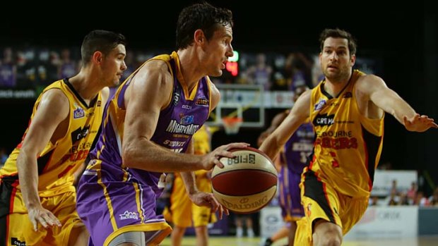Ben Magden of the Sydney Kings charges past Chris Goulding and Tommy Greer of the Melbourne Tigers.
