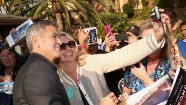 George Clooney gets snapped in a selfie with a fan at the world premiere of Disney's <i>Tomorrowland</i> at Disneyland, Anaheim.