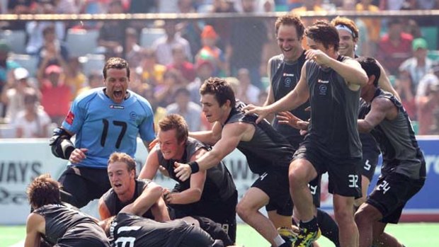 New Zealand players celebrate scoring the winning penalty against England during their bronze medal match.