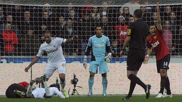 Swansea City's Ashley Williams (6) fouls Manchester United's Robin van Persie (on the ground) during the EPL match on Sunday.