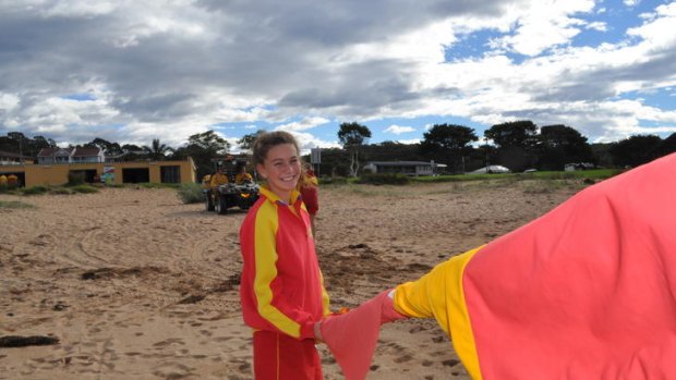 South coast lifesavers packing up the flags on the final day of the surf lifesaving season yesterday. Lifesaver Tess Rowley packing up the flags at Malua Bay beach.