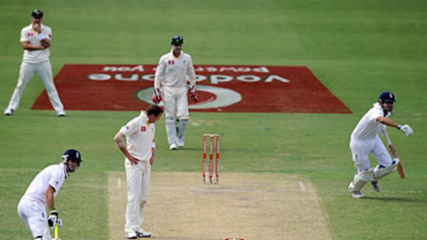 England's Kevin Pietersen (left) and Alastair Cook keep the runs ticking over at the Adelaide Oval yesterday, while a frustrated Peter Siddle can only look on.