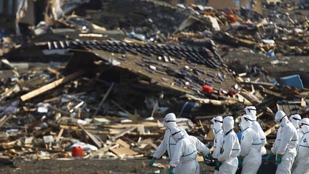 Japanese police officers during a search and recovery operation for missing victims in the area devastated by the March earthquake and tsunami in Namie, Fukushima.