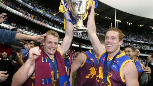 Justin Leppitsch celebrates the Lions' 2002 Grand Final win with the man he's replacing as Brisbane coach, Michael Voss.