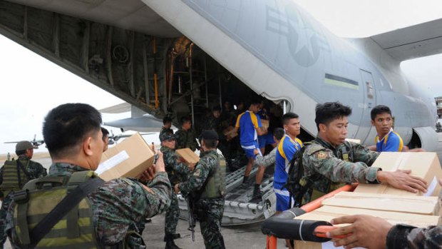 Philippine and US military personnel unload relief goods from a US military C-130 plane at Tacloban airport.