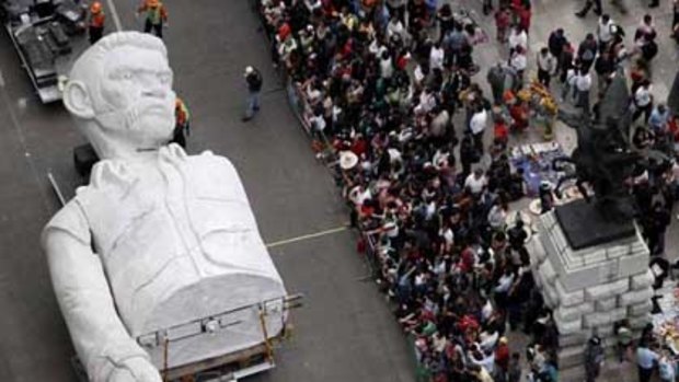 A statue representing people willing to resist  adversity passes the crowd in Mexico City's  bicentennial parade.