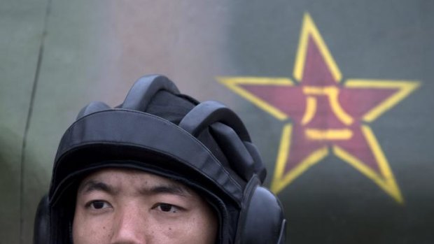 Show of strength: A Chinese People's Liberation Army cadet sits in a Main Battle Tank during a demonstration of military hardware on the outskirts of Beijing.