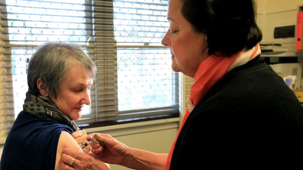 Dr Jenny Smiley gives Elizabeth Moore a flu jab. The government recommends jabs for everyone over 6 months old.
