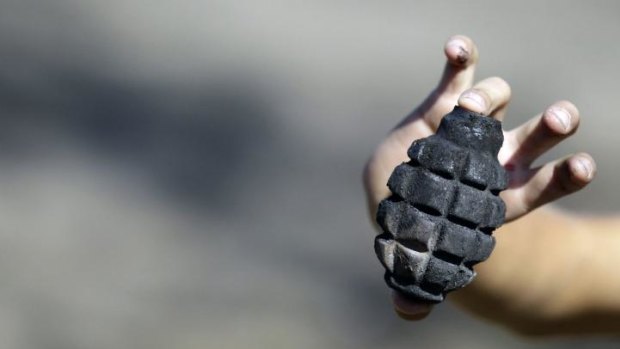 A boy shows unexploded hand grenade in the rebel-controlled village of Novosvitlivka, eastern Ukraine.