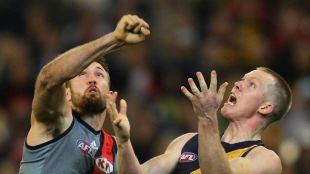 Cale Hooker of Essendon and Jack Riewoldt of Richmond have eyes only for the ball.