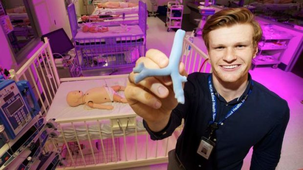 Mitch Finlayson holds a 3D-printed replica of a child's trachea that will be used to train surgeons.