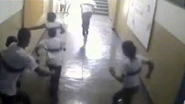 An image taken from a security camera video distributed by the Rio police shows students of the Tasso da Silveira school running from the classroom where a gunman opened fire on them.